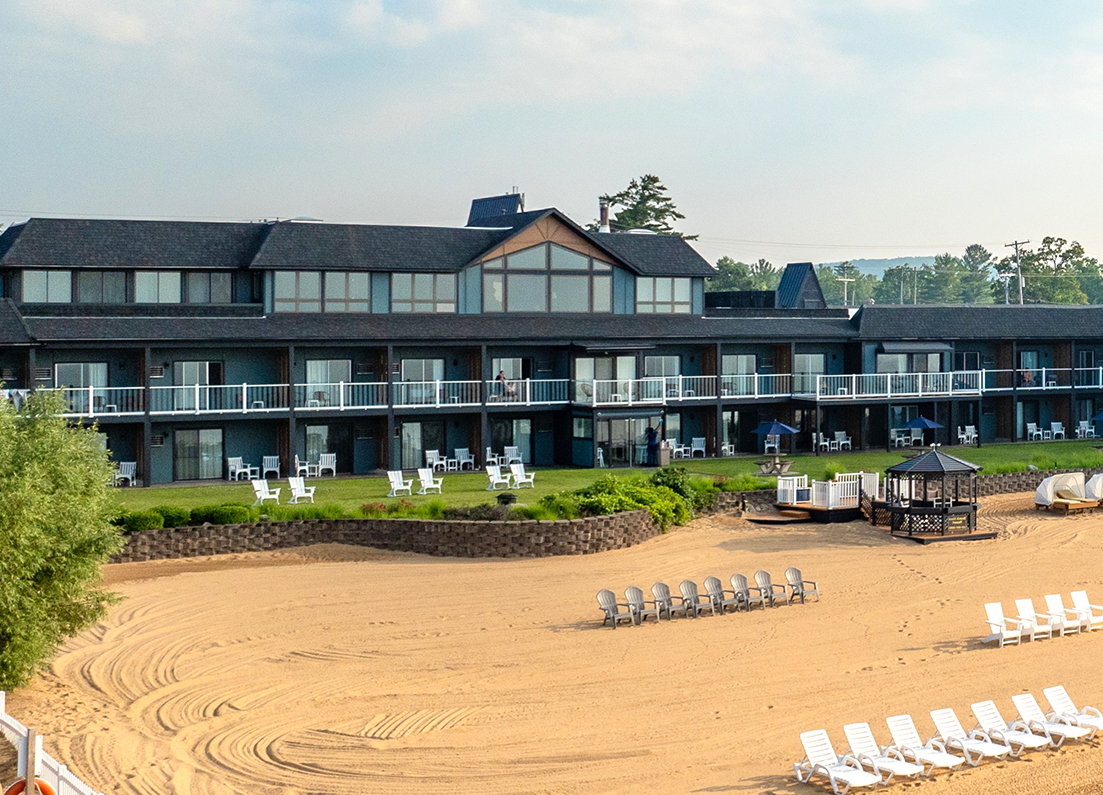 a hotel with a beach and chairs