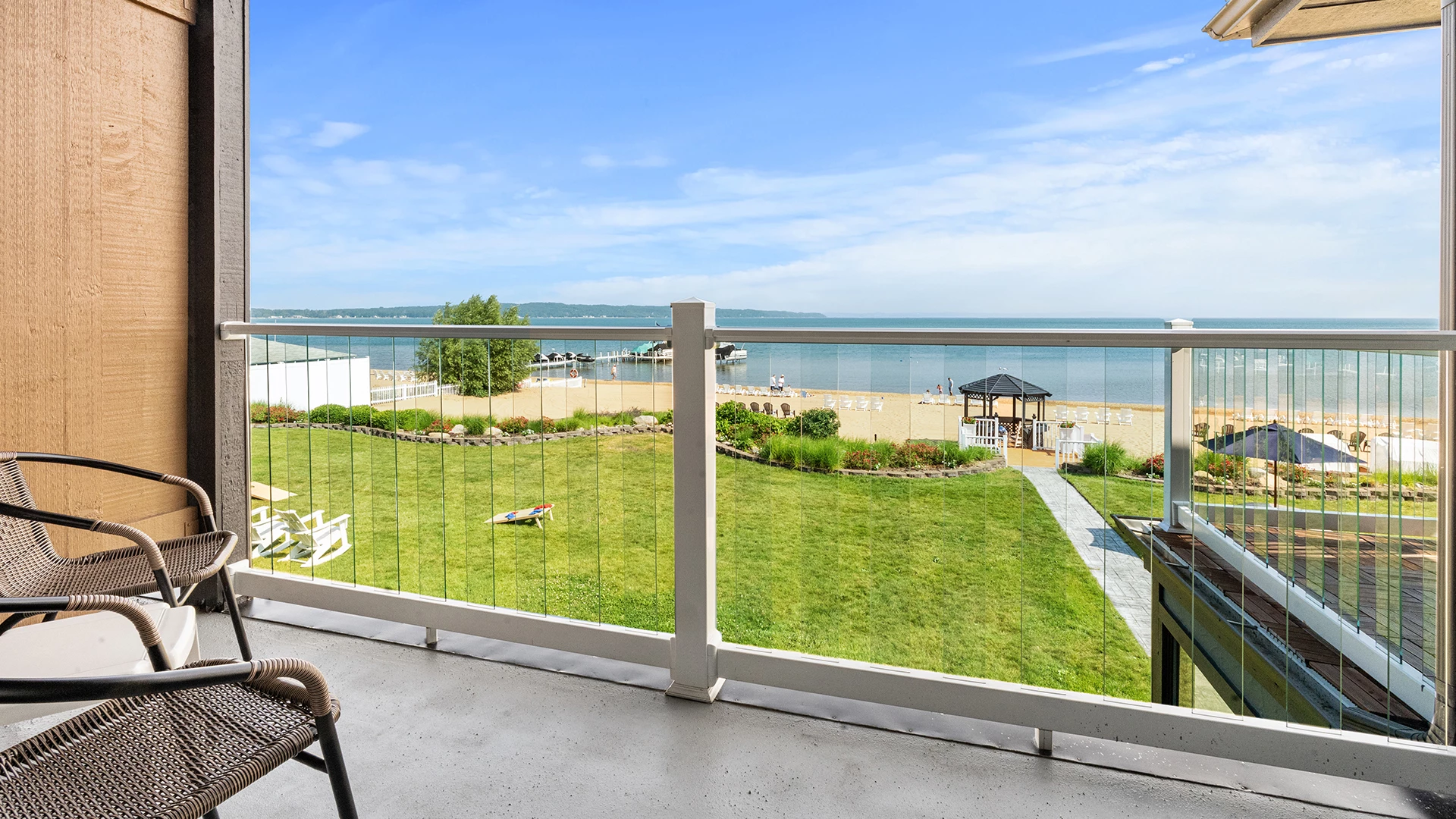 a deck with a view of a beach and a lawn