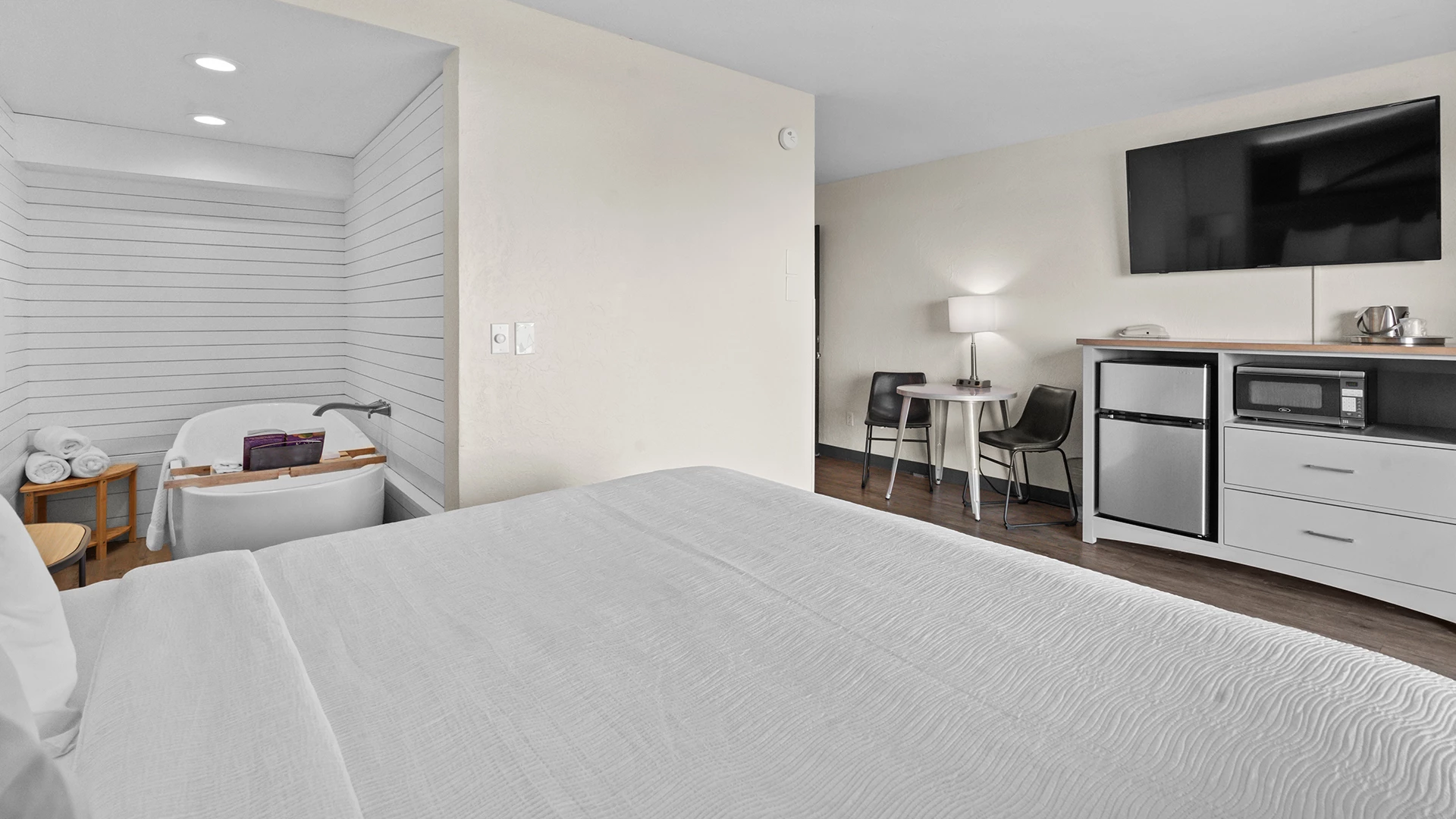 a room with a bed and a sink and a tv