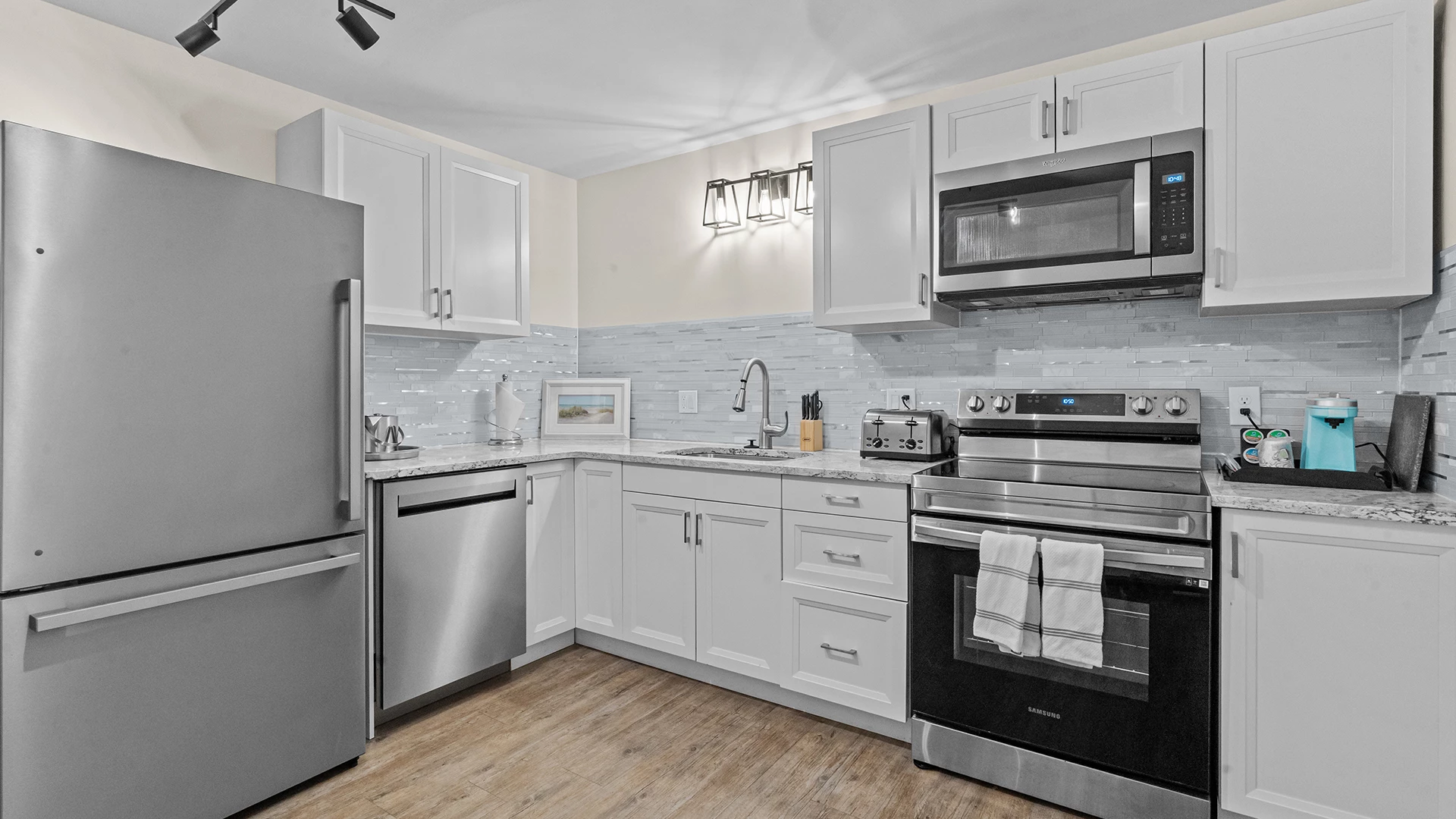 a kitchen with white cabinets and stainless steel appliances