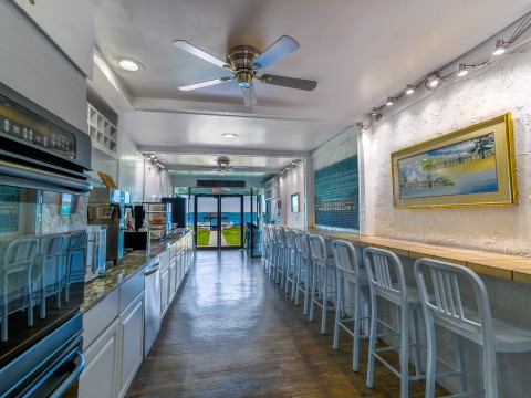 a room with white chairs and a table with a fan