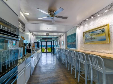 a room with white chairs and a table with a fan