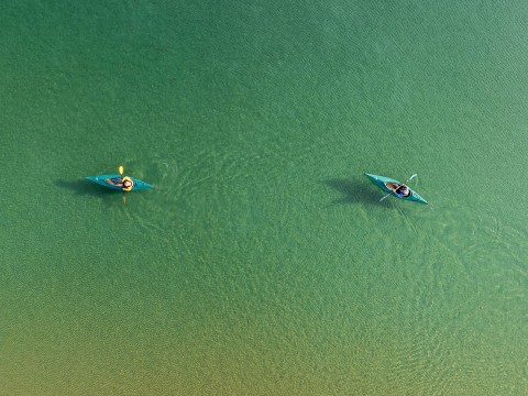 a couple of people in kayaks in a body of water