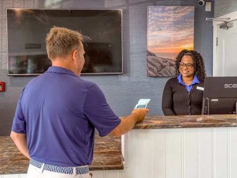 a man standing at a counter with a woman behind him