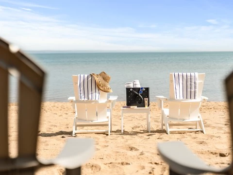 a beach chairs with towels and a hat on the beach