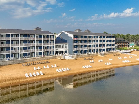 a beach with chairs and a building on the beach
