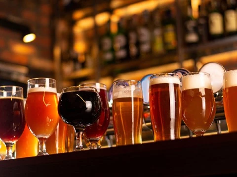A selection of beverages in various glasses on a bar.
