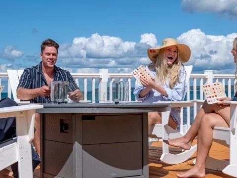 a group of people sitting at a table playing cards