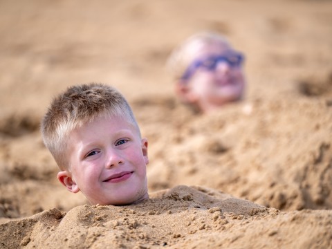 a boy buried in sand