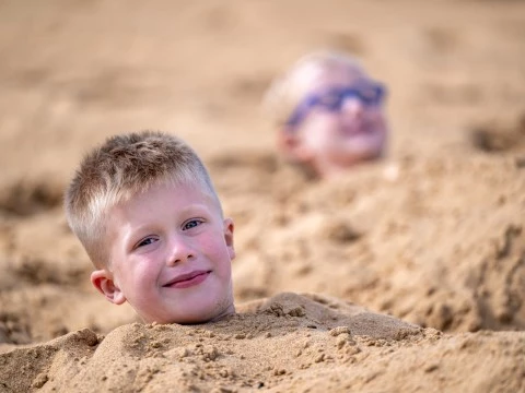 a boy buried in sand