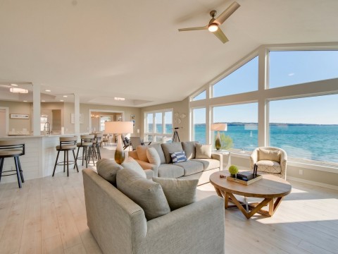 a living room with a large window overlooking the water