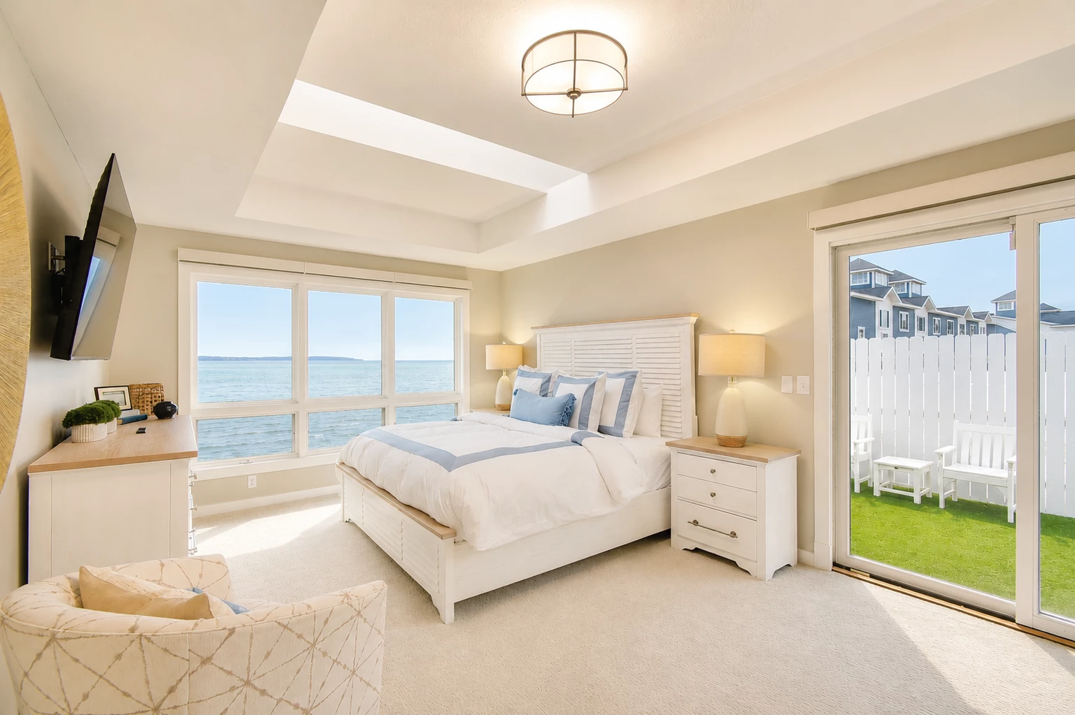 a bedroom with a large window and a view of the ocean