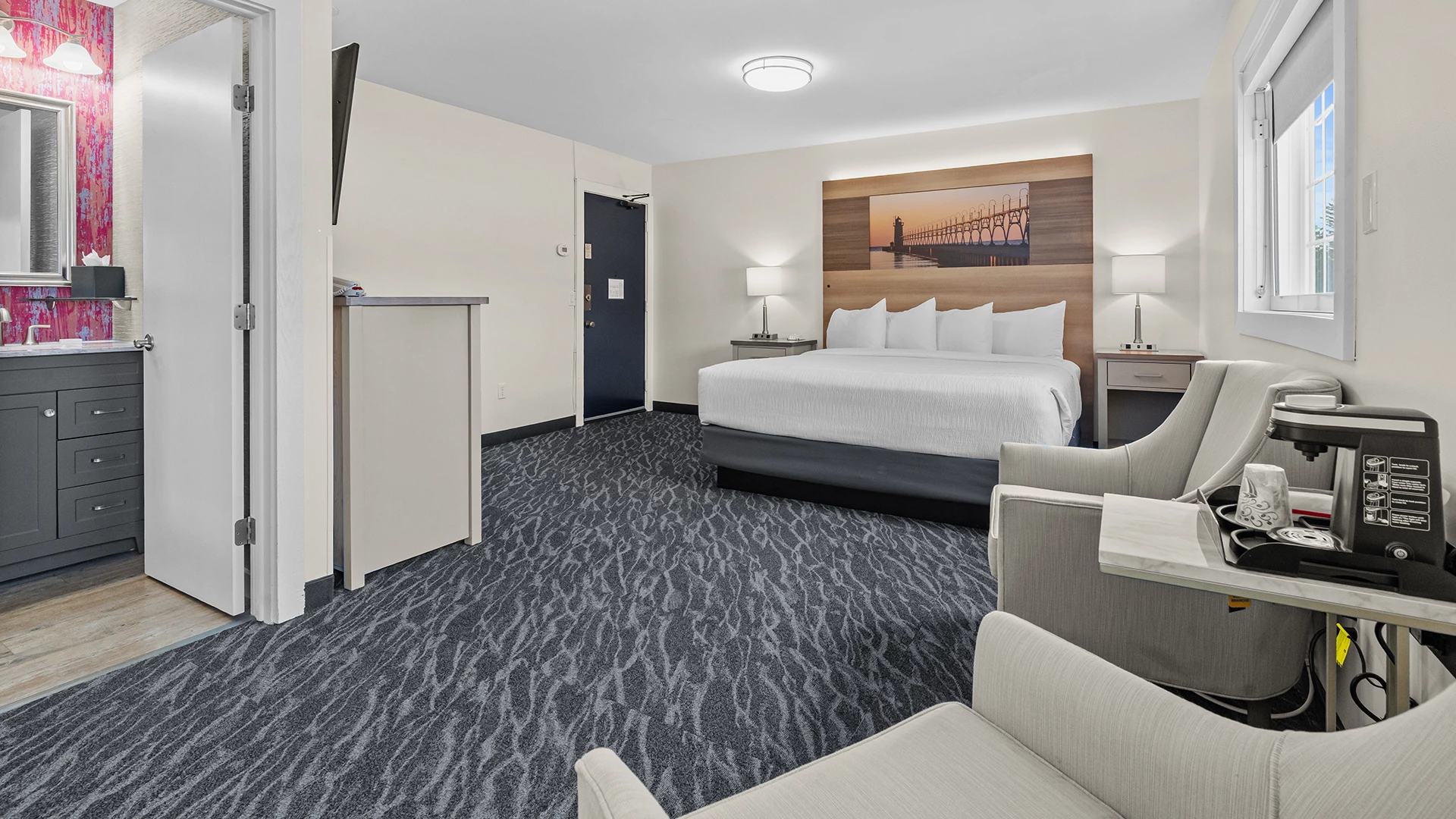 a hotel room with a bed and chairs
