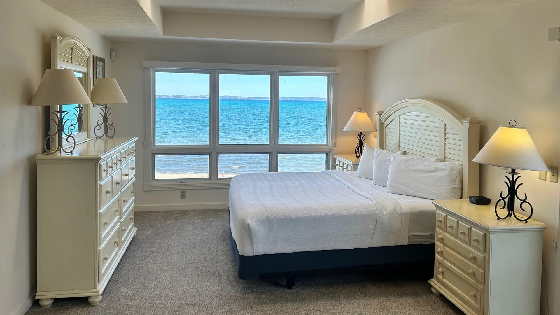 a bedroom with a large window overlooking the ocean