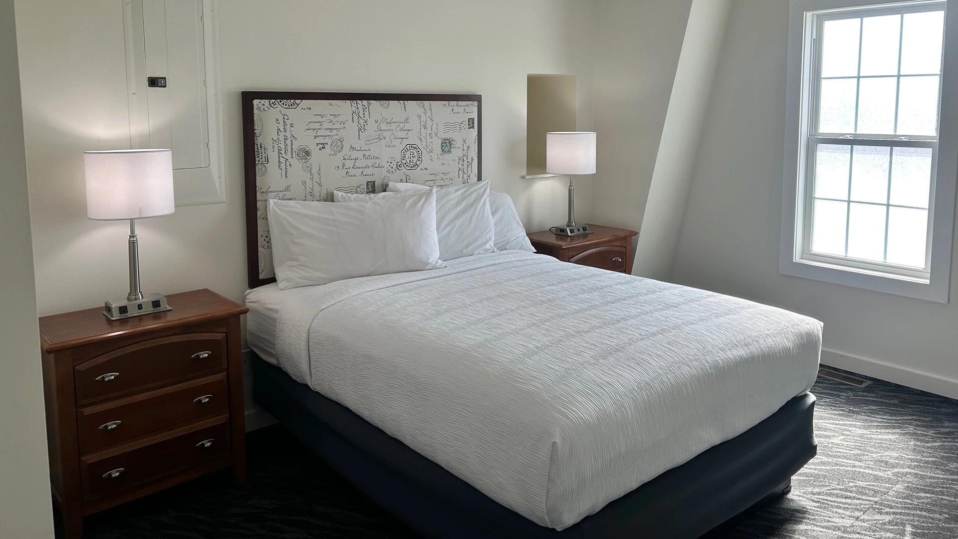 a bed with white sheets and a lamp