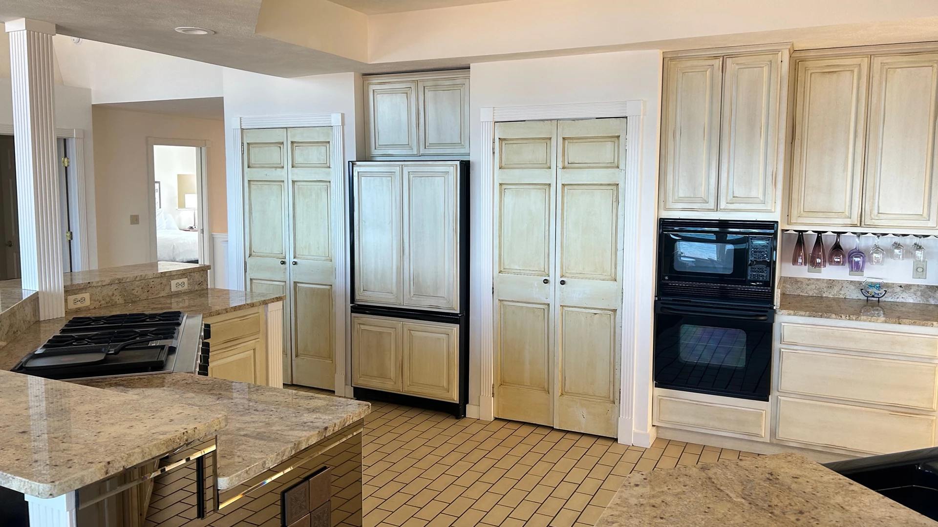 a kitchen with white cabinets and black appliances
