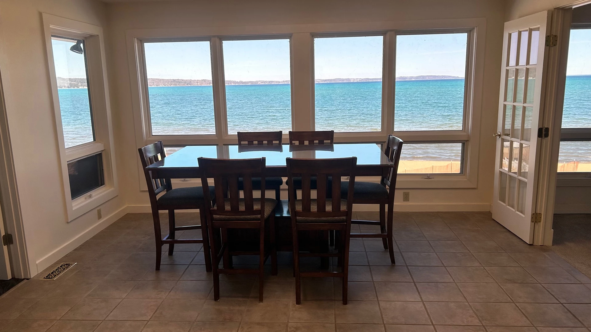 a table and chairs in a room with a view of the ocean