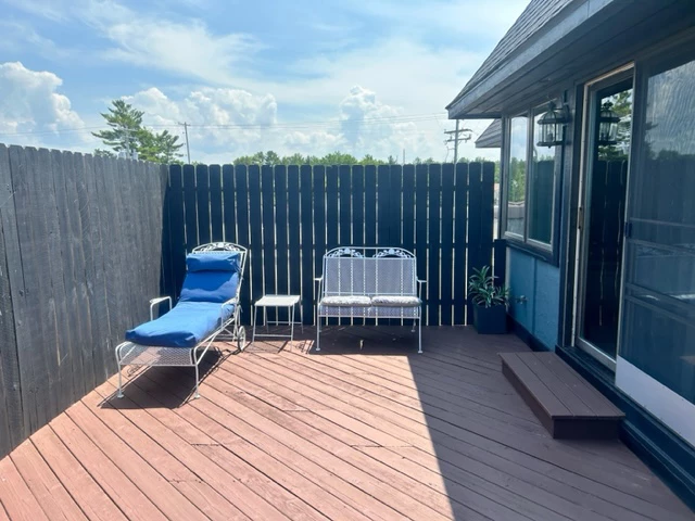a deck with chairs and a fence