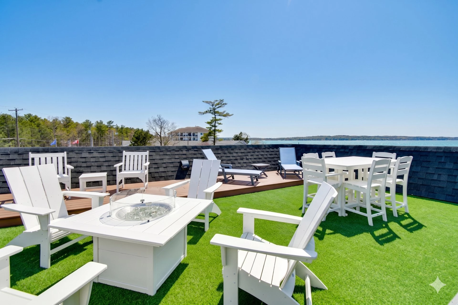 a patio with white furniture and chairs on a green lawn
