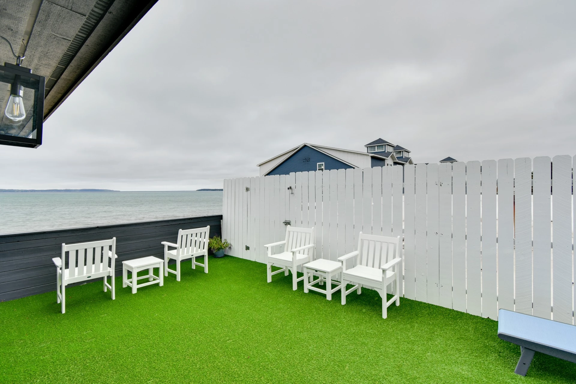 a deck with white chairs and a fence