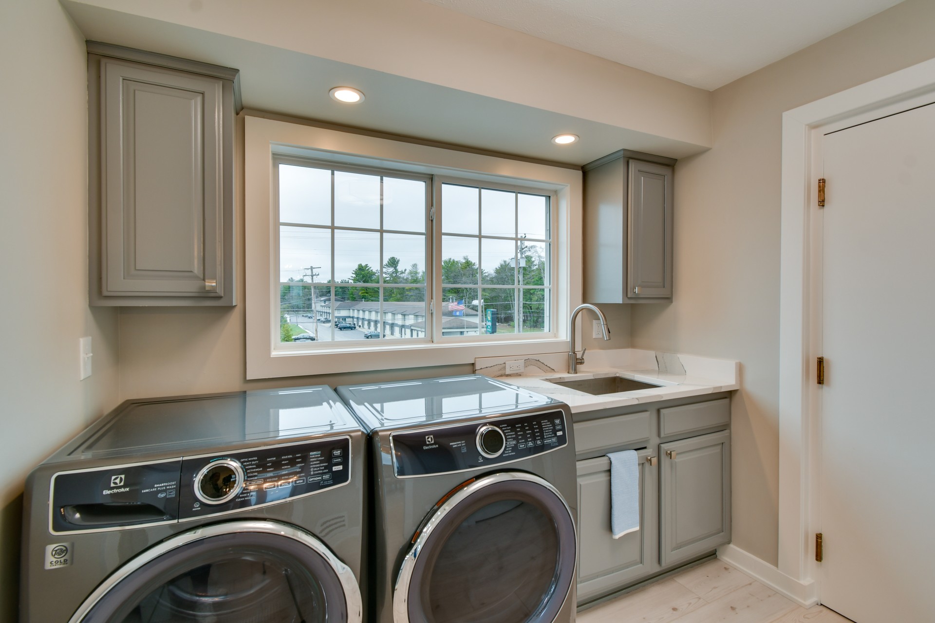 a laundry room with a washing machine and sink