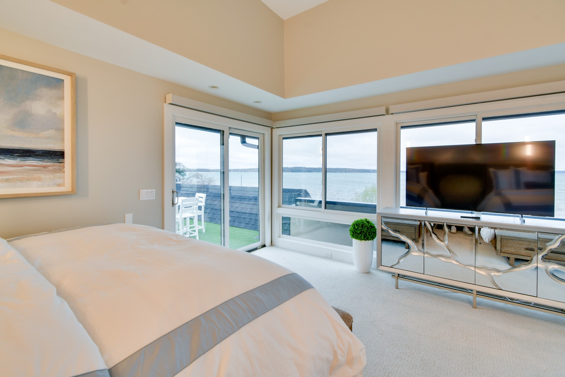a bedroom with a large window overlooking the water