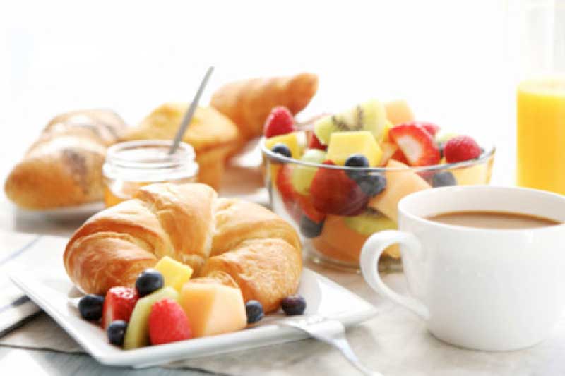 a breakfast with croissants and fruit