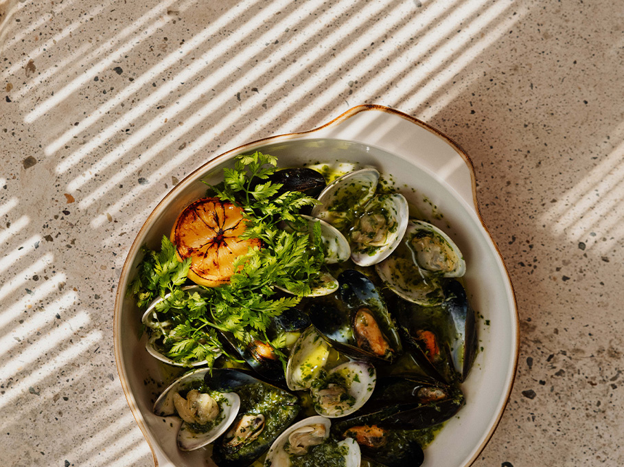 a bowl of food with a lemon slice and parsley