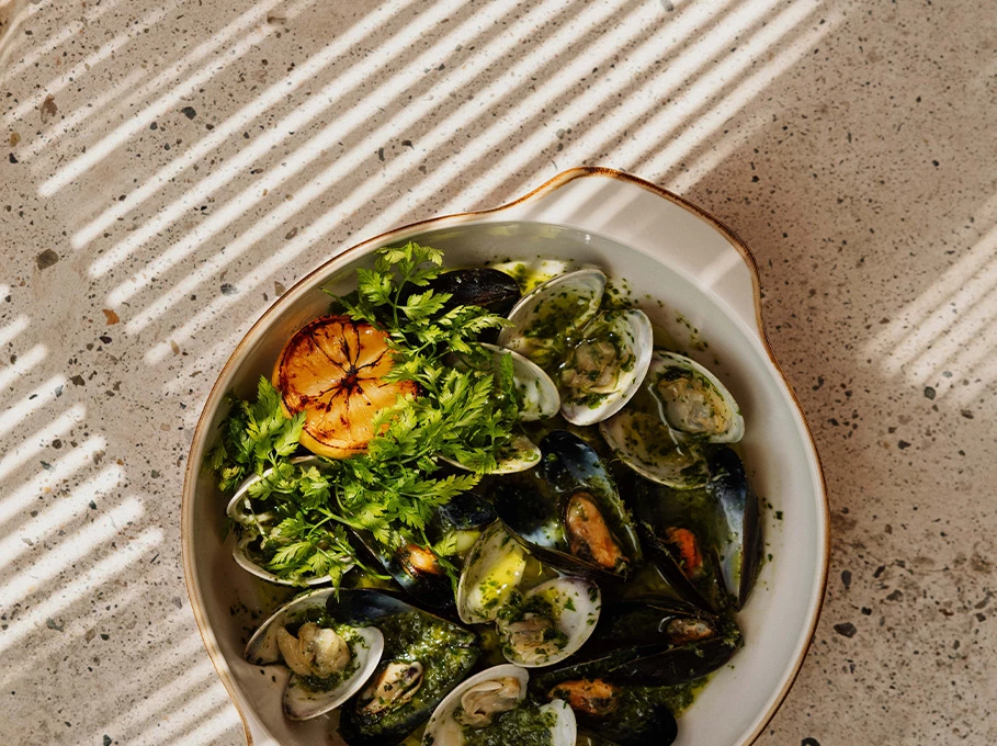 a bowl of food with a lemon slice and parsley