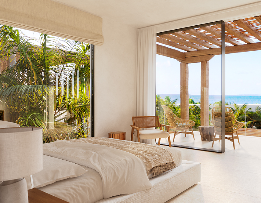a bedroom with a view of the ocean and a beach