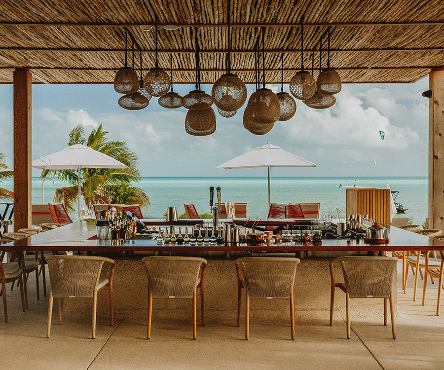 a bar with chairs and umbrellas on a beach