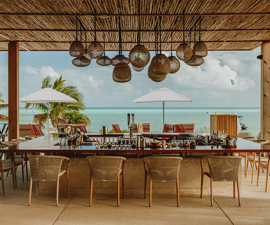 a bar with chairs and umbrellas on a beach