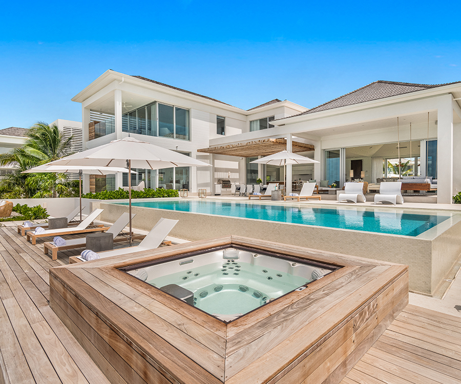a swimming pool and a hot tub in front of a house
