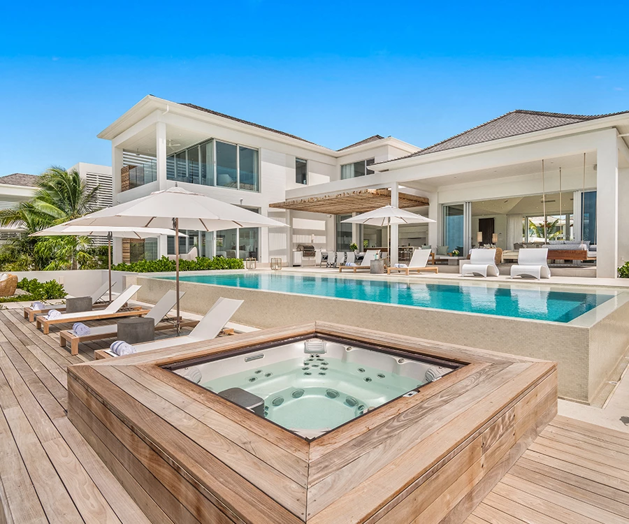 a swimming pool and a hot tub in front of a house
