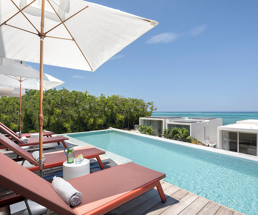 a pool with lounge chairs and umbrellas