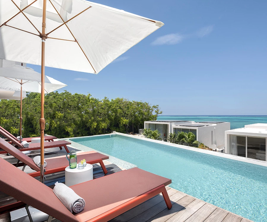 a pool with lounge chairs and umbrellas