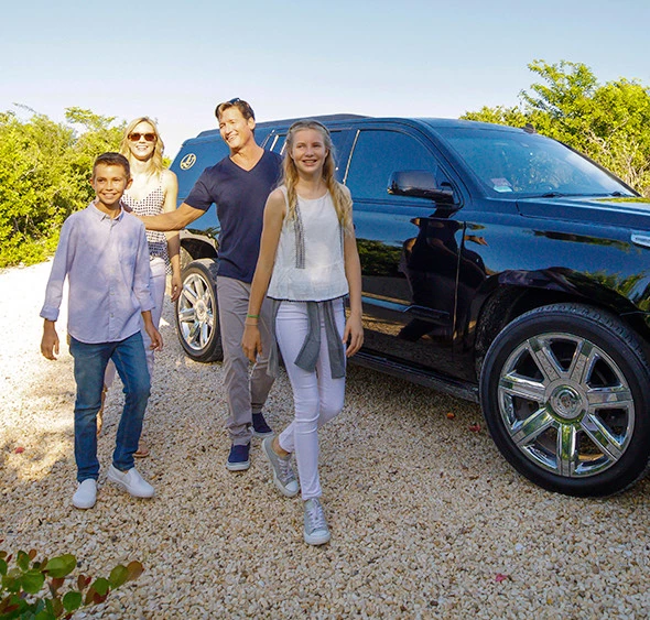 a group of people posing in front of a car