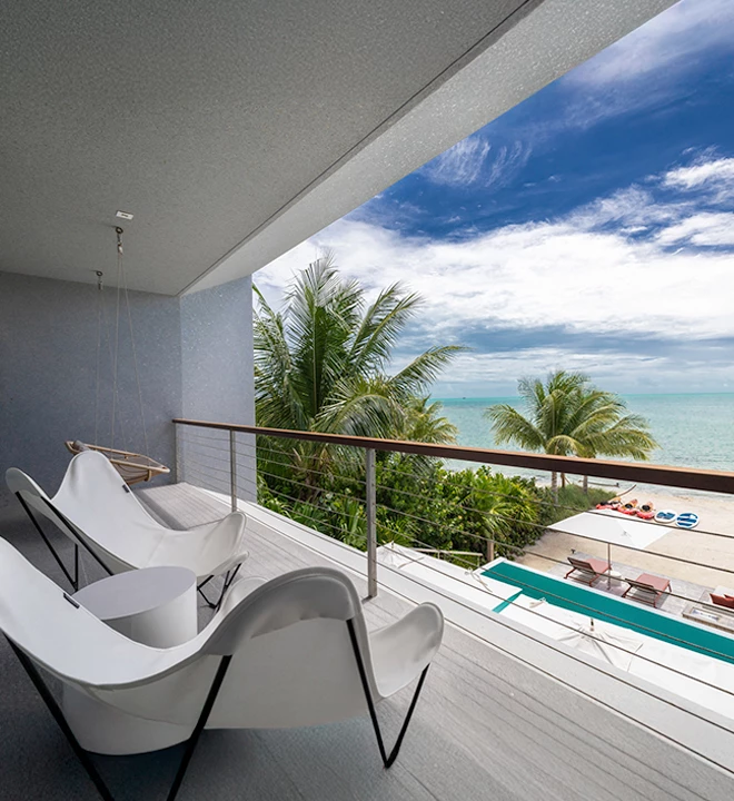 a balcony with chairs and a view of the ocean