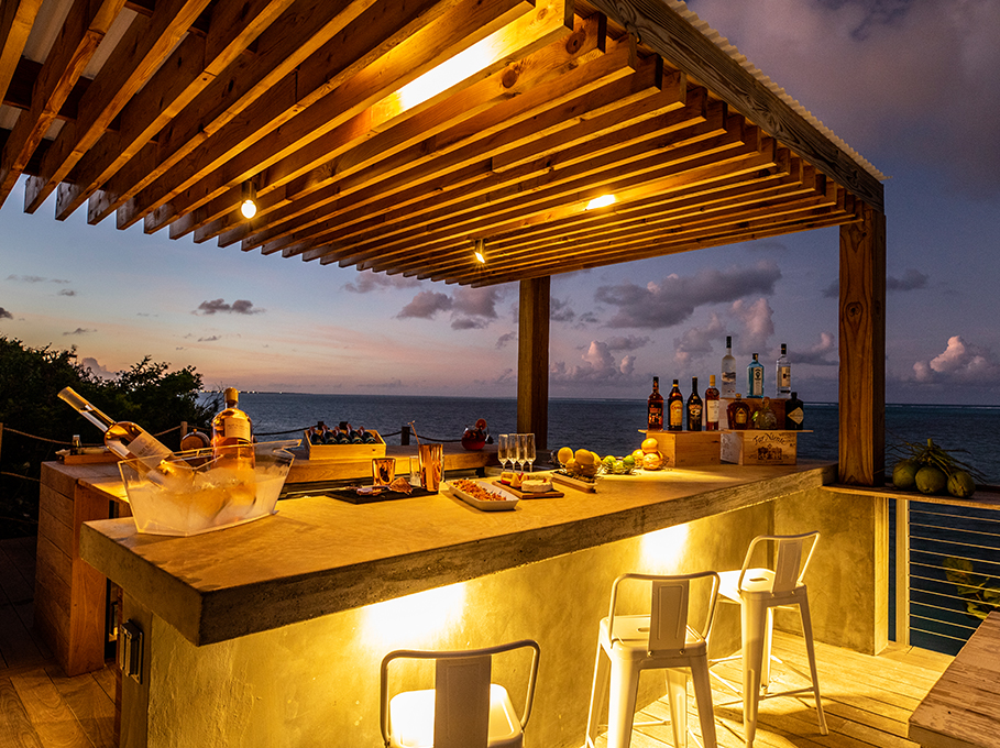 a bar with drinks and glasses on a deck