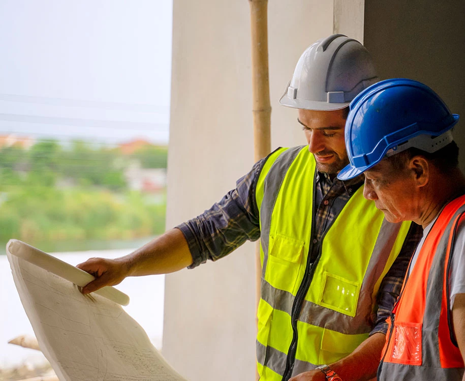 men wearing hardhats looking at a piece of paper