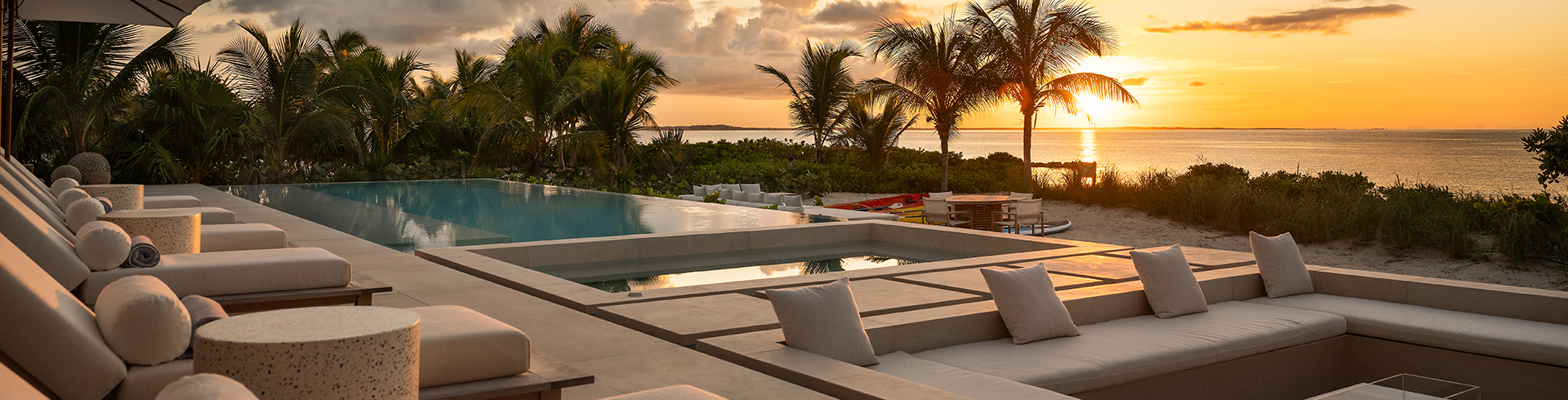 a pool with a view of the ocean and palm trees