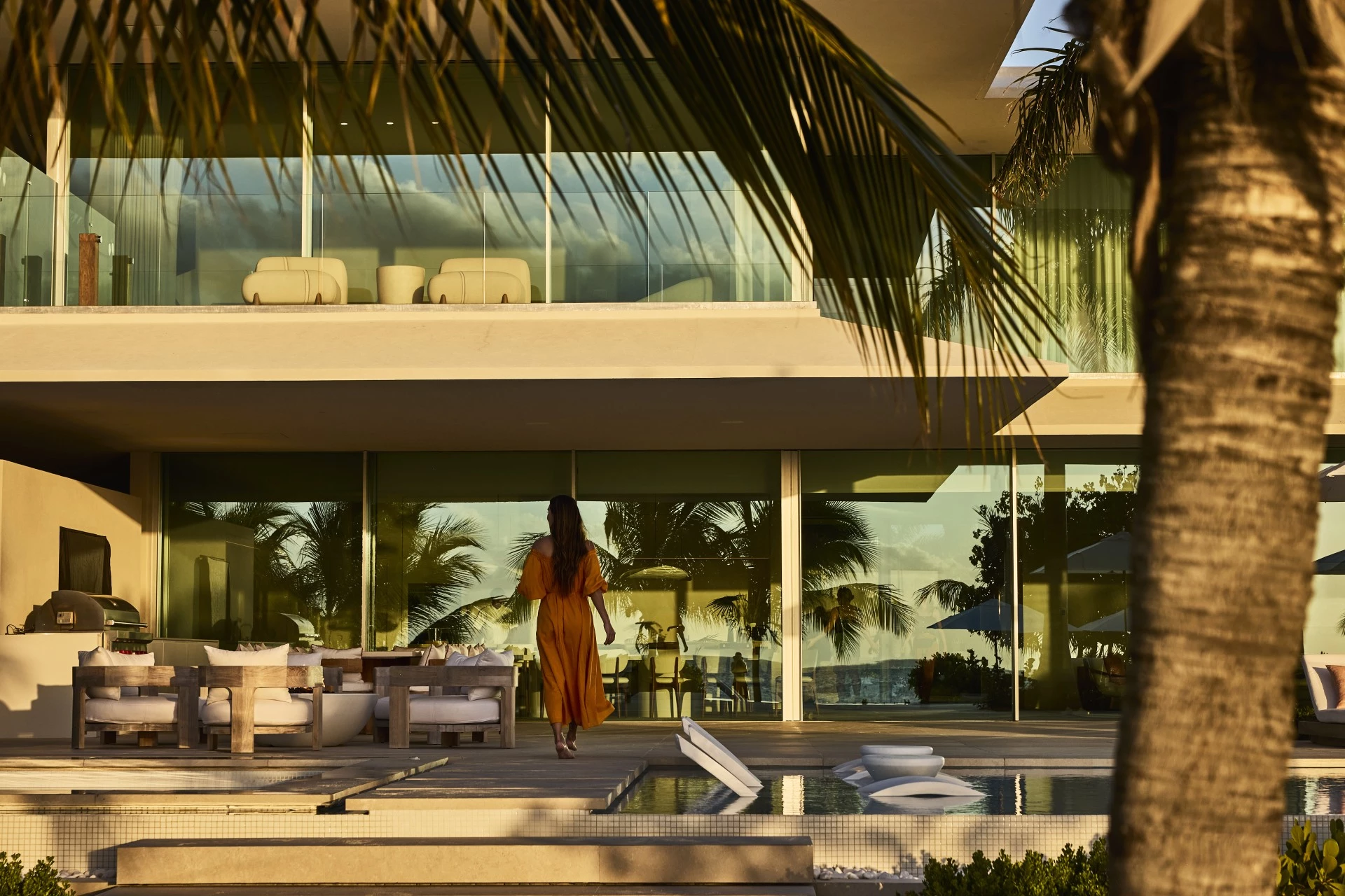 a woman walking in front of a large glass building