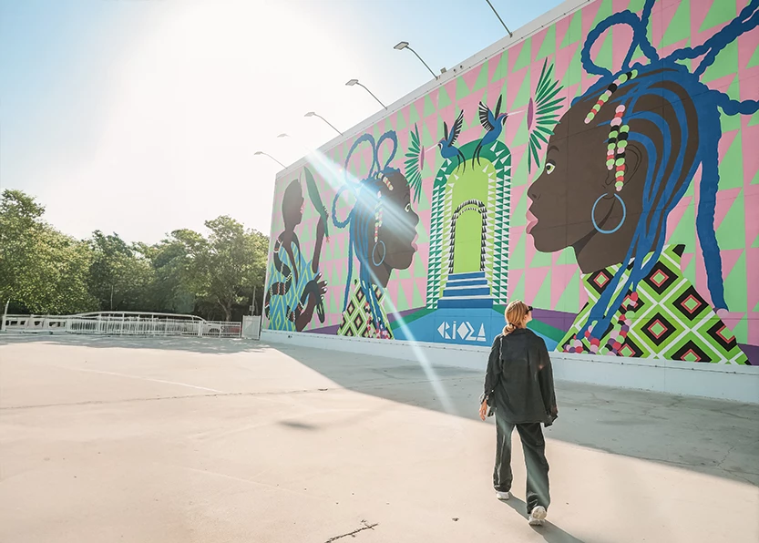 a woman walking in front of a mural