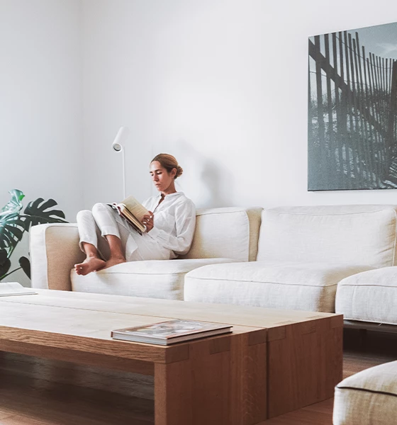 a woman sitting on a couch reading a book