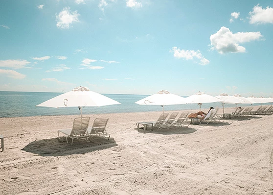 a beach with chairs and umbrellas