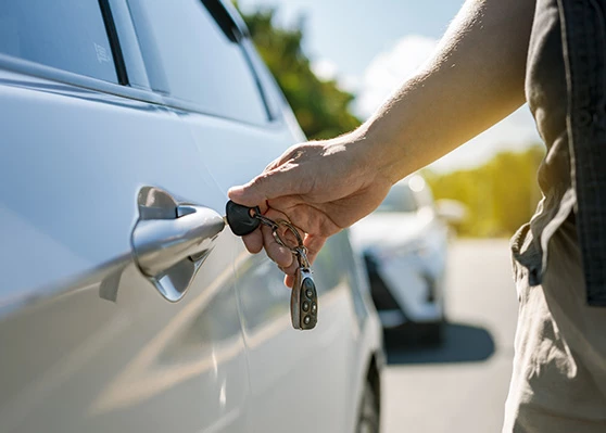 a person holding a key to a car door
