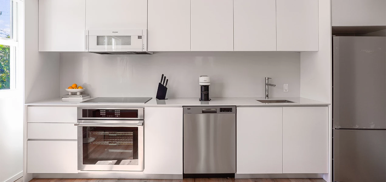 a kitchen with white cabinets and appliances