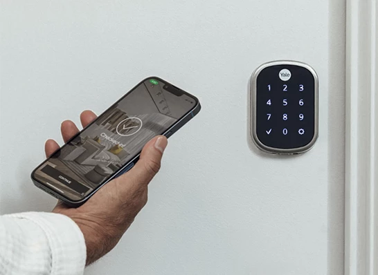 a hand holding a phone and a keypad