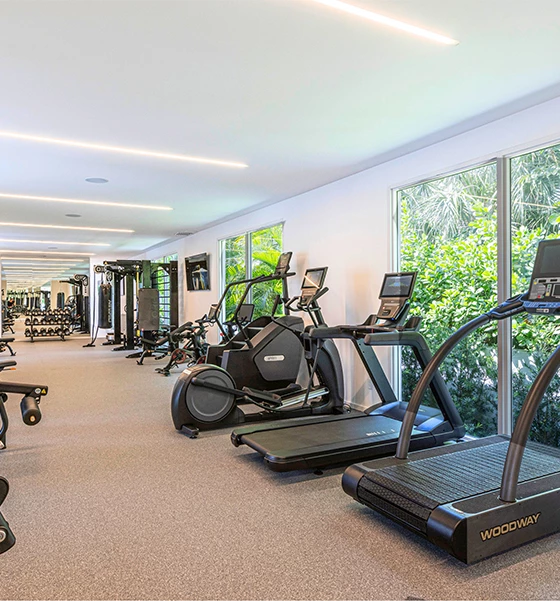 a room with exercise machines and windows