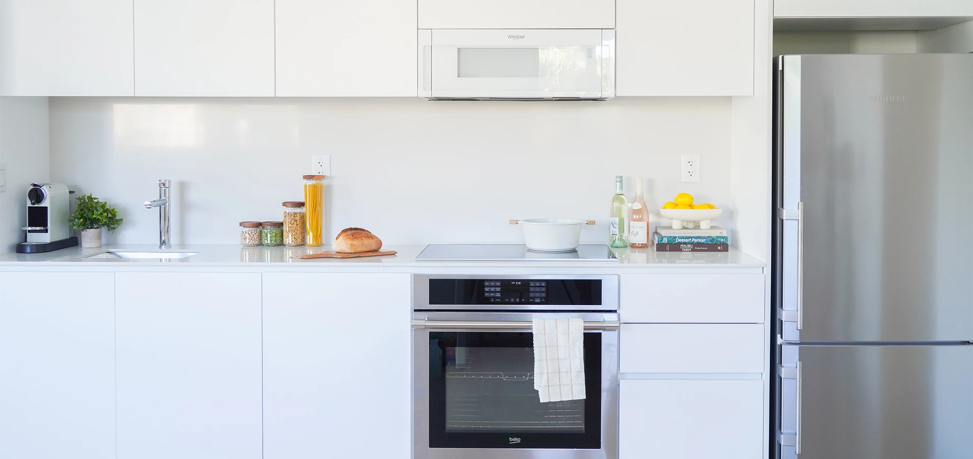 a kitchen with white cabinets and a white oven